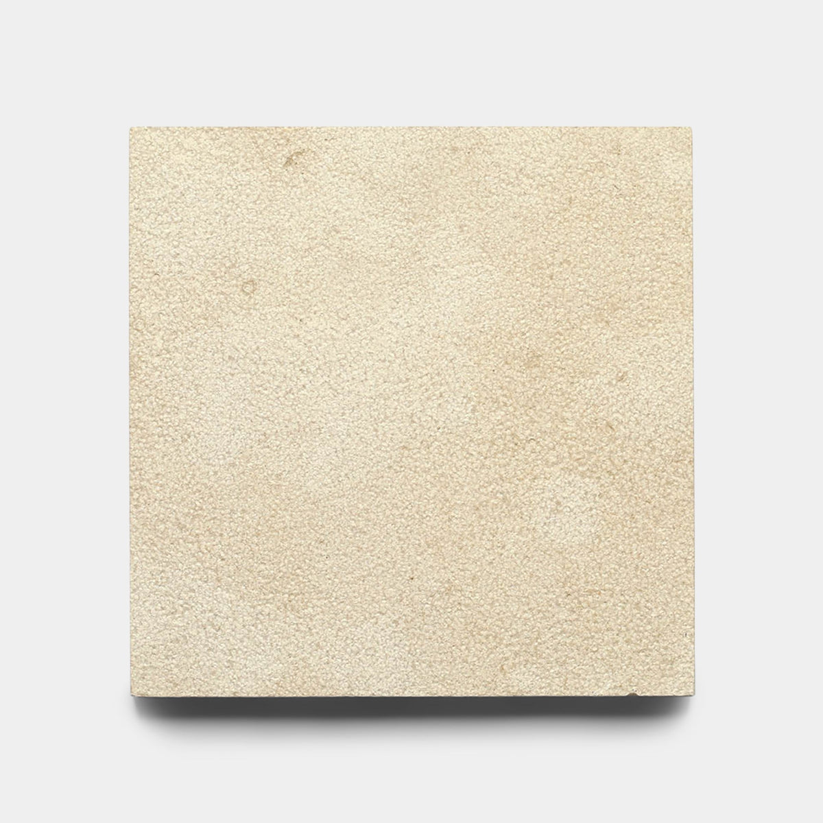 A Buff 12x12 Bush Hammered Moroccan Limestone tile sample by Zia Tile, square and beige with a slightly textured matte finish, shown against a plain white background.