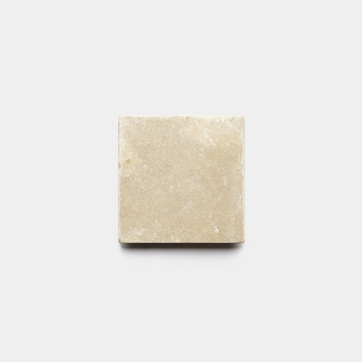 A Buff 6x6 + Honed tile sample by Zia Tile, rectangular and beige like a handmade tile, is displayed on a plain white background and viewed from above.