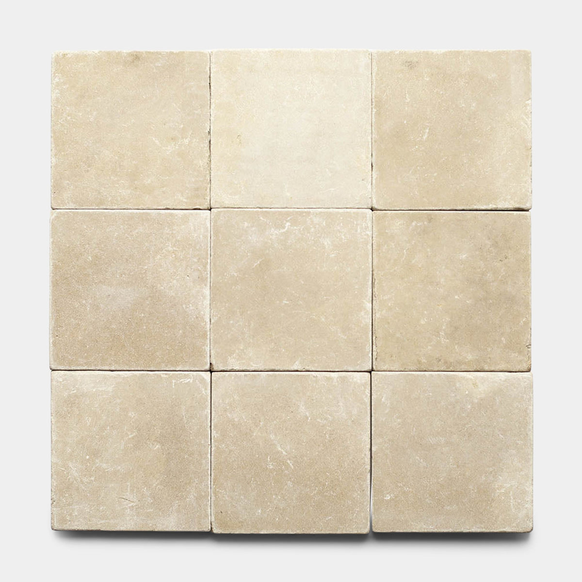 Nine Buff 6x6 + Honed, Sample tiles from Zia Tile are arranged in a 3x3 grid, each showcasing unique shades and subtle textures that highlight the handmade artistry of the brand against a neutral backdrop.