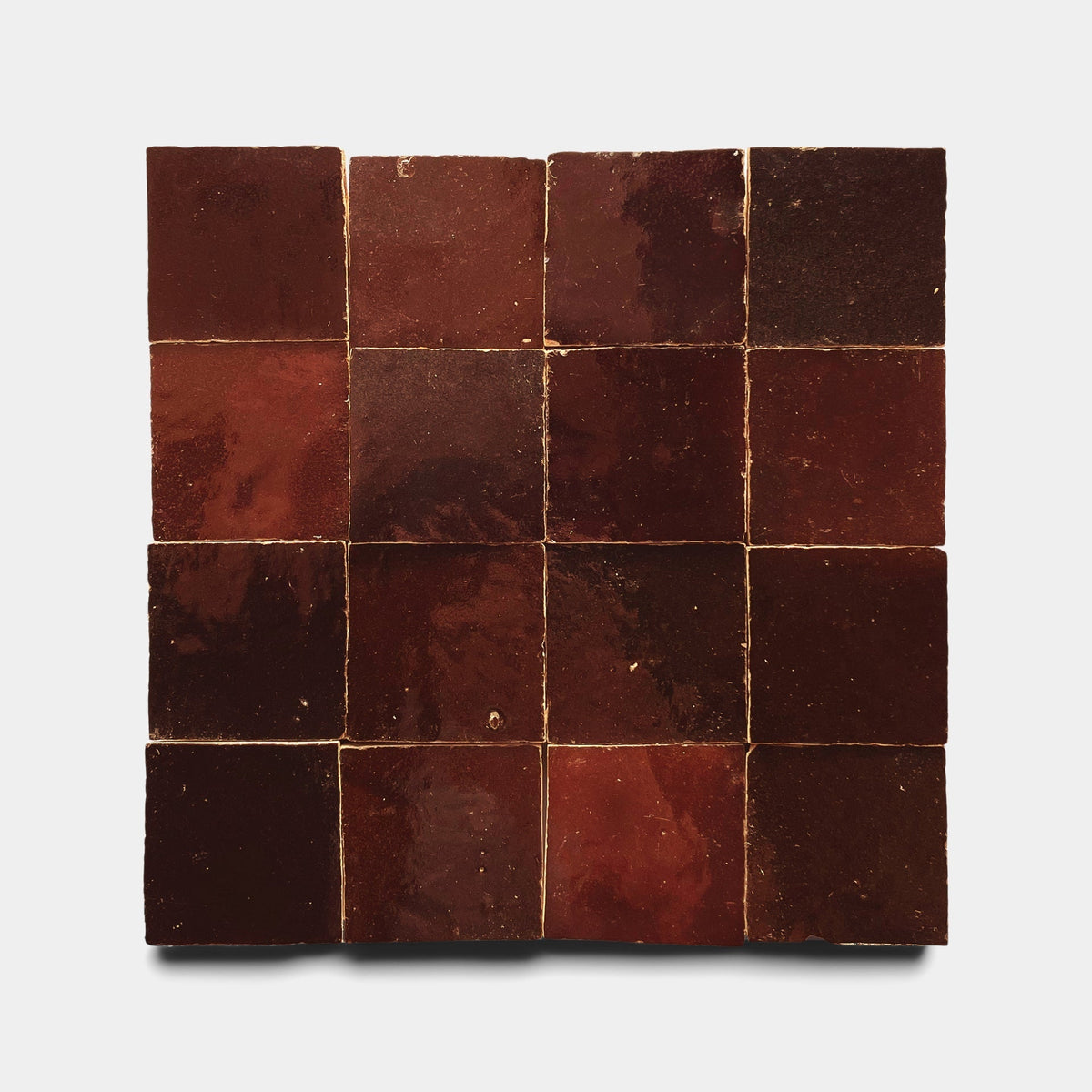A square grid of 16 Zia Tile Burnt Sugar 2x2 ceramic tiles in deep reddish-brown with a glossy finish, displayed on a plain white background.