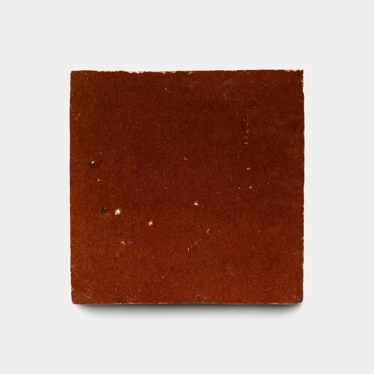 A single “Burnt Sugar 2x6, Sample” tile by Zia Tile, handcrafted with a smooth, slightly textured brown surface, is centered against a plain white background.