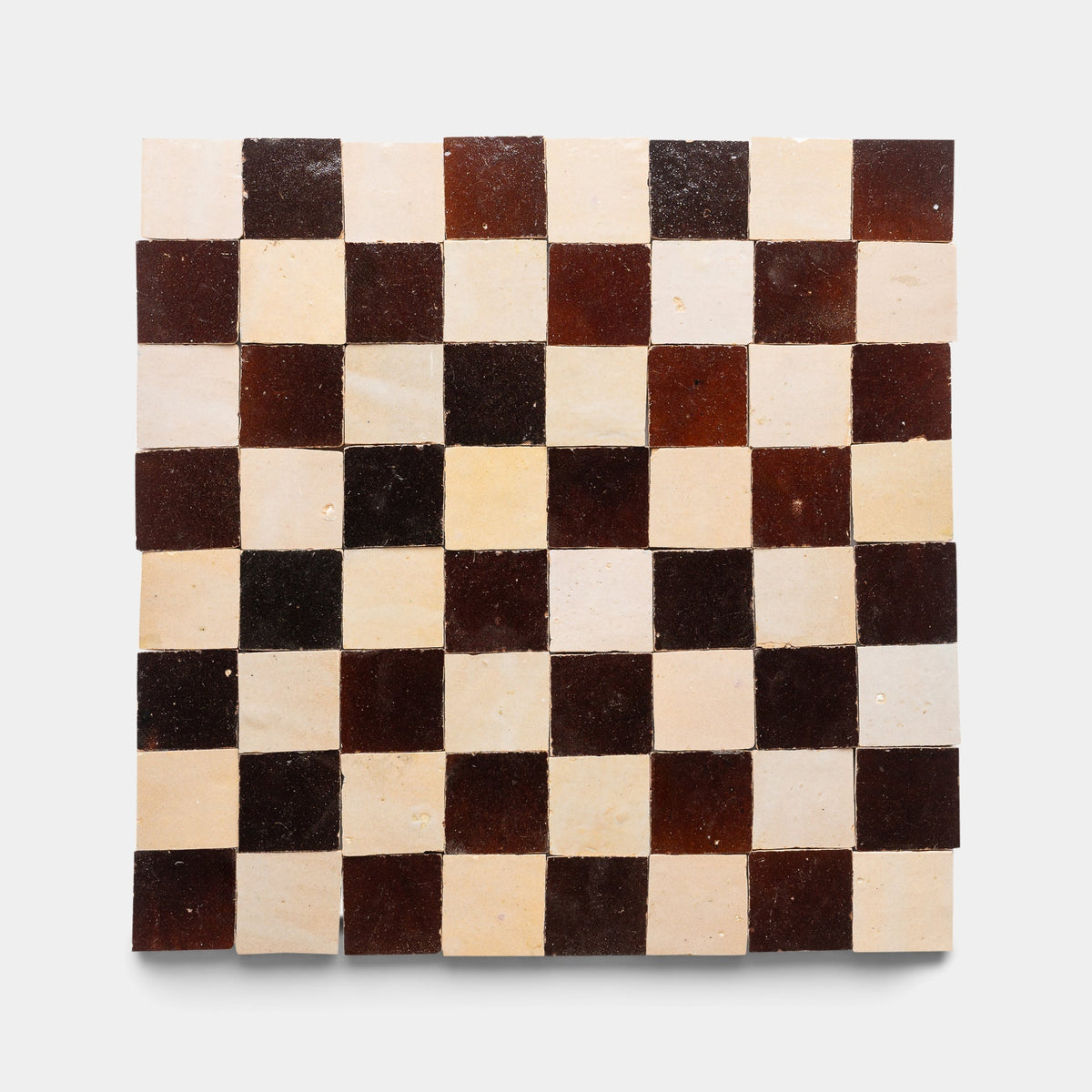 The Burnt Sugar + Glazed Earth Checkerboard sample from Zia Tile features alternating dark brown and light beige ceramic tiles with a slightly uneven, handmade texture, displayed against a plain white background.
