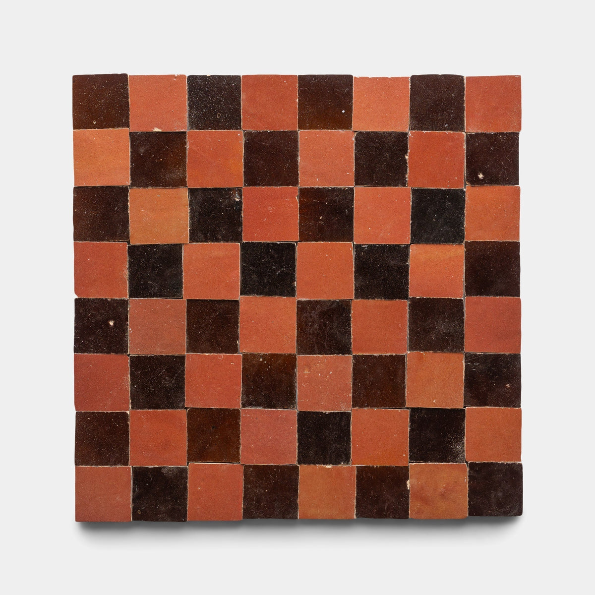 The Burnt Sugar + Terra Rosa Checkerboard Sample by Zia Tile features an 8x8 grid of alternating dark brown and reddish-orange handmade tiles, displayed on a plain white background.