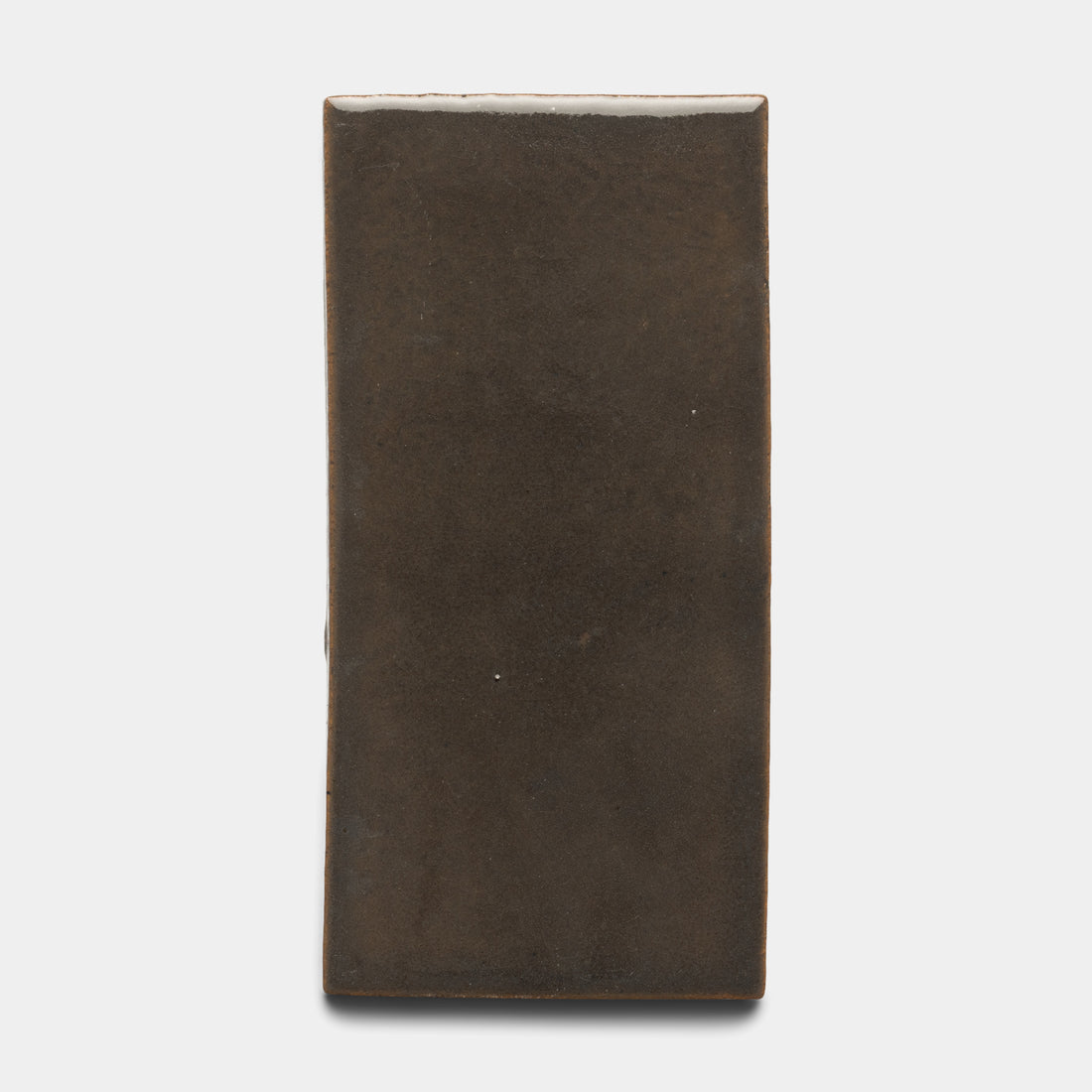 The Zia Tile Cacao 4x8 Rectangle is a ceramic tile featuring a smooth, matte dark brown finish and softly rounded edges, shown against a plain white background.