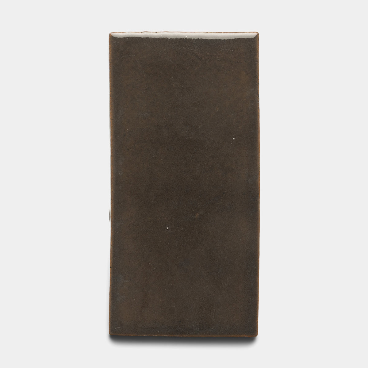 The Zia Tile Cacao 4x8 Rectangle is a ceramic tile featuring a smooth, matte dark brown finish and softly rounded edges, shown against a plain white background.
