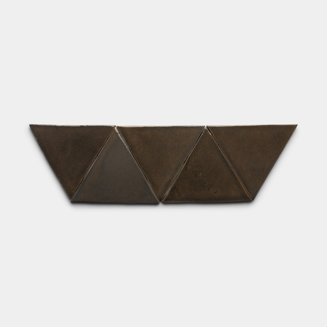 The Cacao Triangle by Zia Tile is a geometric metal wall sculpture featuring four connected dark bronze triangles in a linear zigzag pattern, displayed against a plain white background.