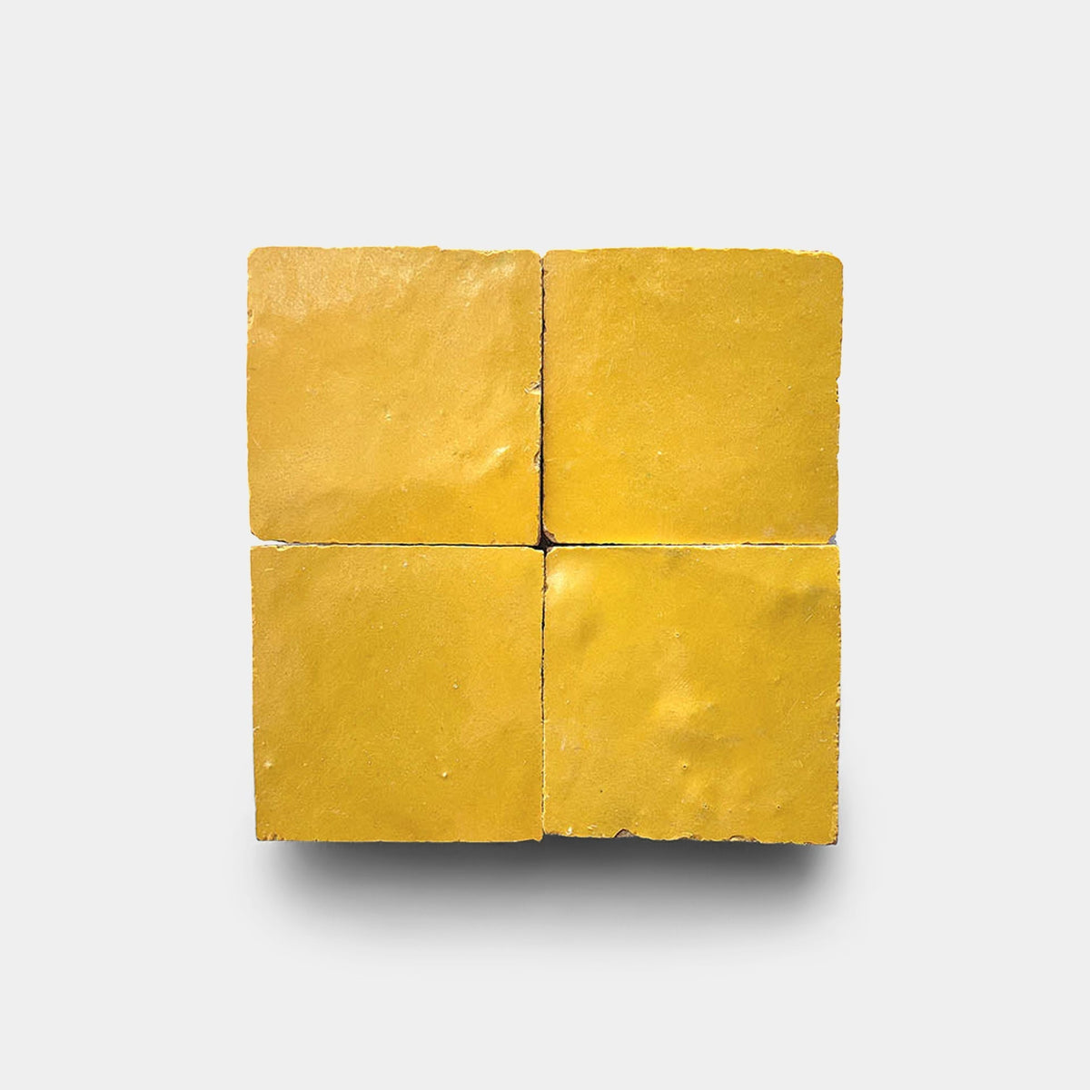 Four Zia Tile Cadmium 2x6 cement tile samples arranged in a square grid on a plain white background, with subtle shadows beneath.