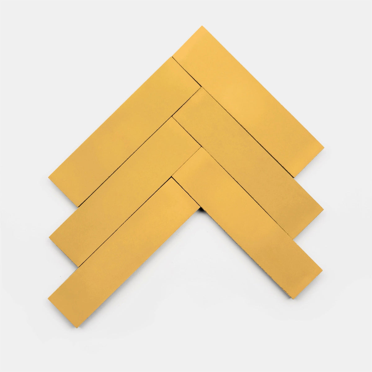 Four rectangular Cadmium 2x6 tiles by Zia Tile are arranged in a herringbone pattern on a white background, forming an upward-pointing arrow shape.