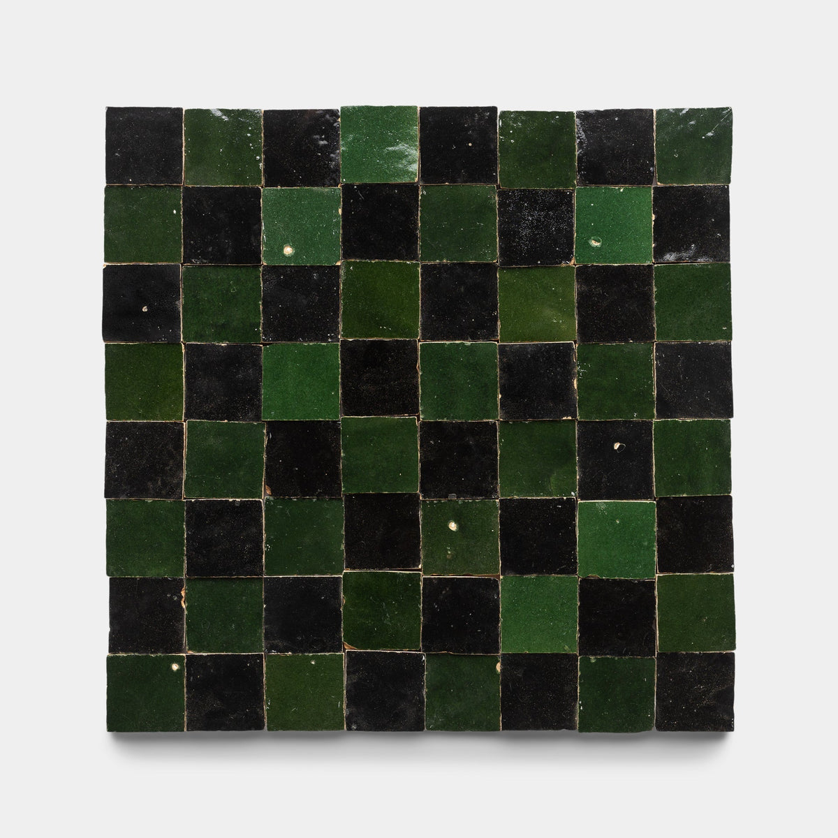 A square grid of small, glossy Zia Tile Carbon Black + Racing Green Checkerboard tiles, featuring slight surface variations and artisanal details for a handcrafted look.