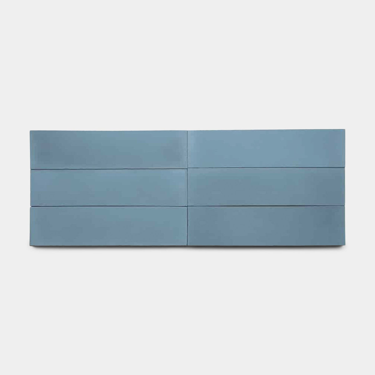 A modern, minimalist blue dresser with six drawers stands against a white background, accented by Carolina Blue 4x4 tiles from vendor-unknown, inspired by Zia Tile's handmade look.