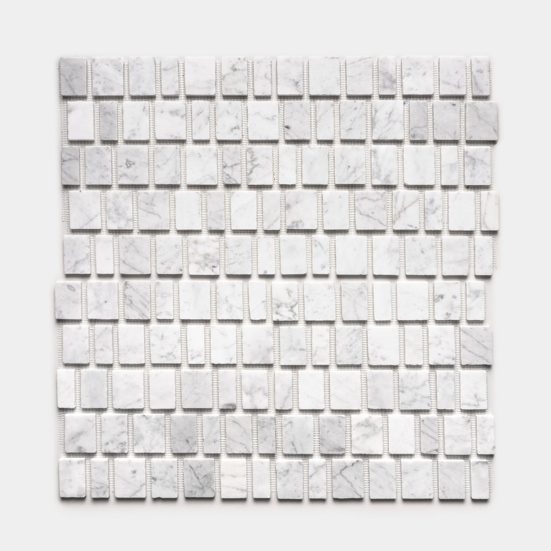 Scarpa in Carrara by Zia Tile features a grid of small, rectangular white marble tiles with subtle gray veining, arranged in even rows on mesh backing and displayed against a plain white background.