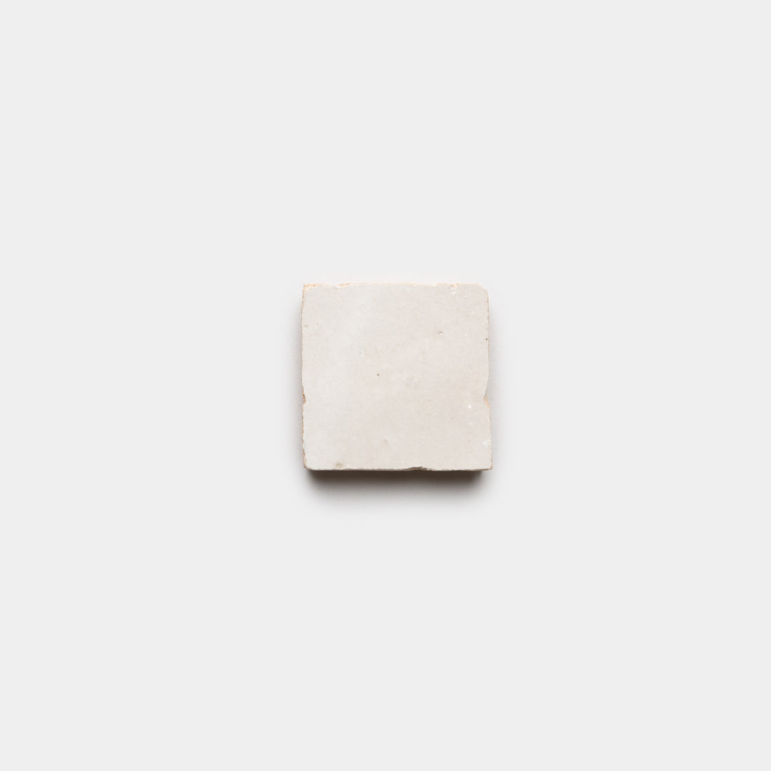 A single Casablanca 2x2 tile by Zia Tile, featuring slightly rough white edges, is centered on a plain light gray background.