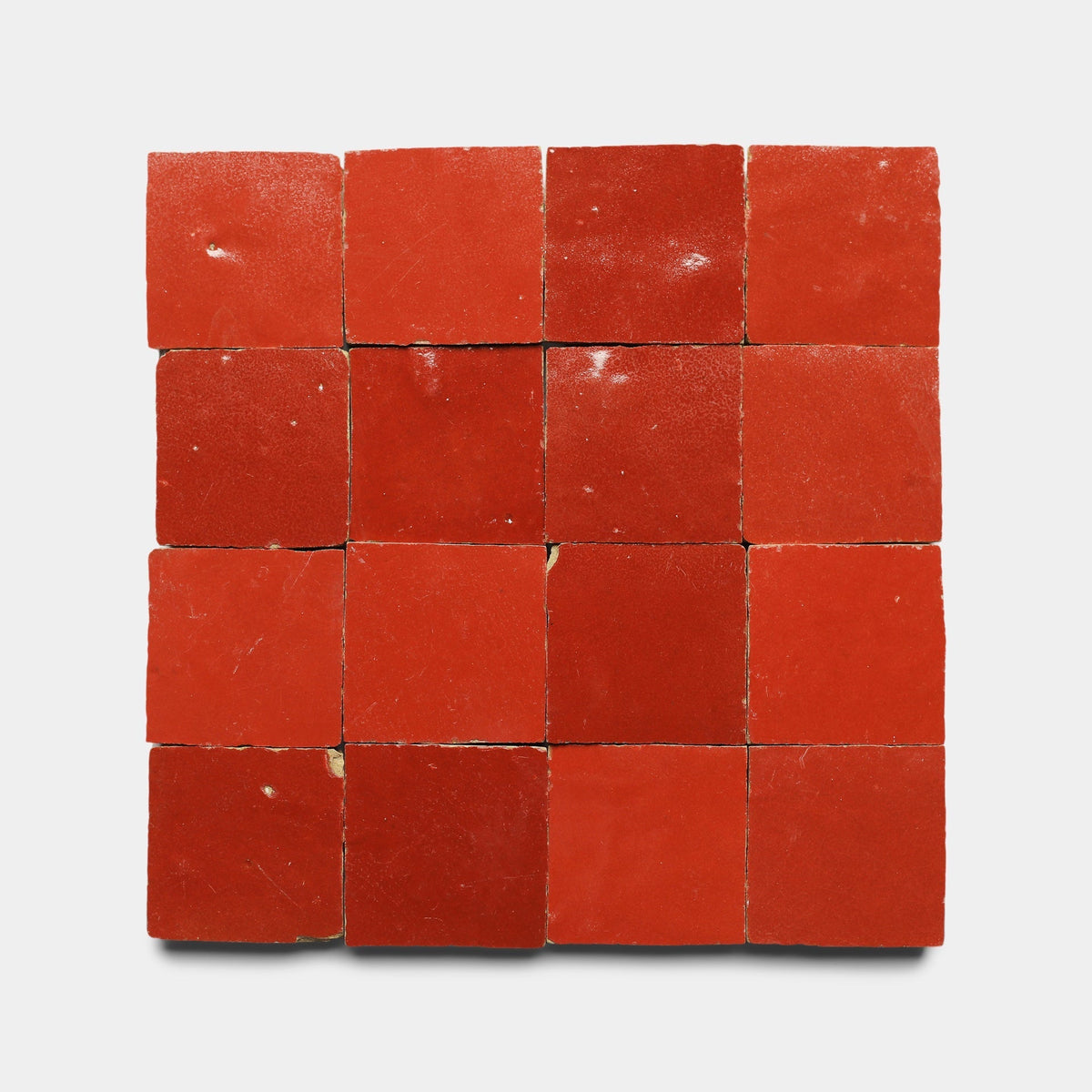 A grid of sixteen Zia Tile Cayenne 2x2 samples, arranged four by four on a white background. The handmade tiles show subtle shade and texture variations.