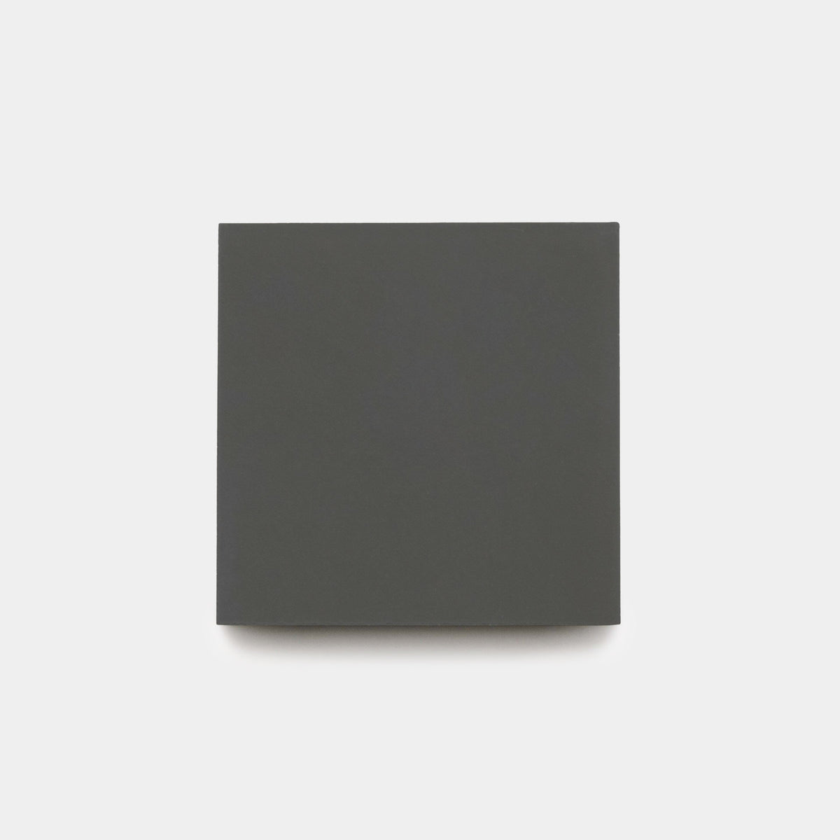 A closed, plain, dark gray square book is centered on a light gray background. The cover is blank with no text or images.
