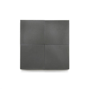 Four matte, dark gray Charcoal 4x4 tiles are arranged in a neat 2x2 grid on a plain white background, highlighting their modern look—ideal for bathroom floors or a stylish kitchen backsplash.