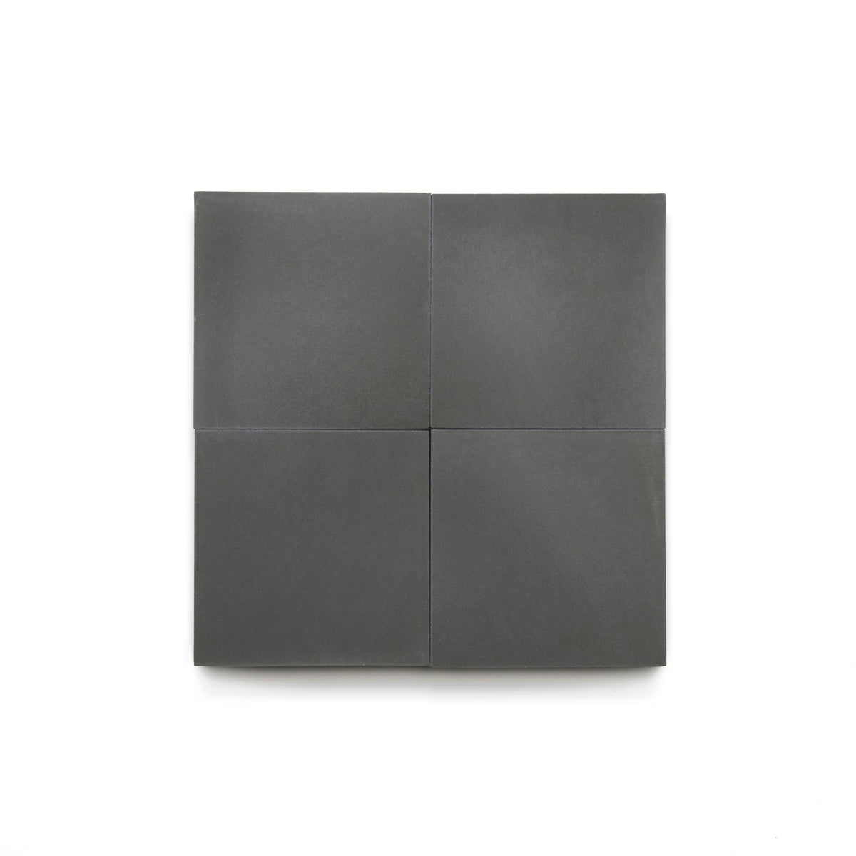 Four matte, dark gray Charcoal 4x4 tiles are arranged in a neat 2x2 grid on a plain white background, highlighting their modern look—ideal for bathroom floors or a stylish kitchen backsplash.