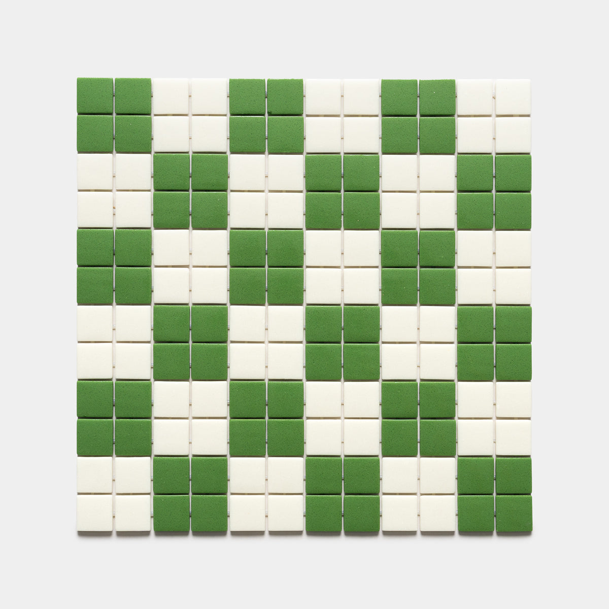 The Zia Tile Cheque Clover + Milk, Sample showcases a square grid of small tiles with a checkered pattern of alternating green and white squares, neatly arranged to form diagonal stripes across the surface.