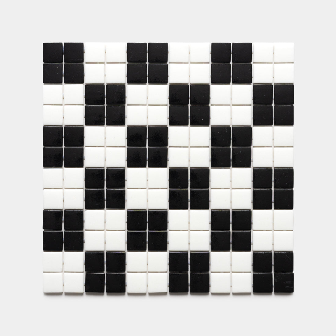 The Cheque Jet Black + Paperwhite sample by Zia Tile features a grid of black and white square tiles in a geometric pattern, creating a diamond and checkerboard effect on a light background.