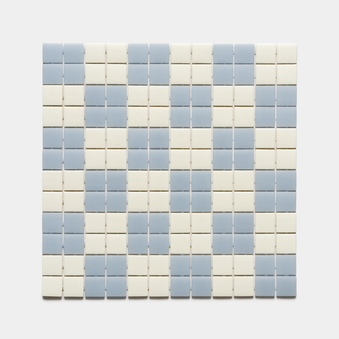 Zia Tile’s Cheque Tranquil Blue + Milk sample features a grid of small square tiles in alternating horizontal rows of light blue and off-white on a plain background.