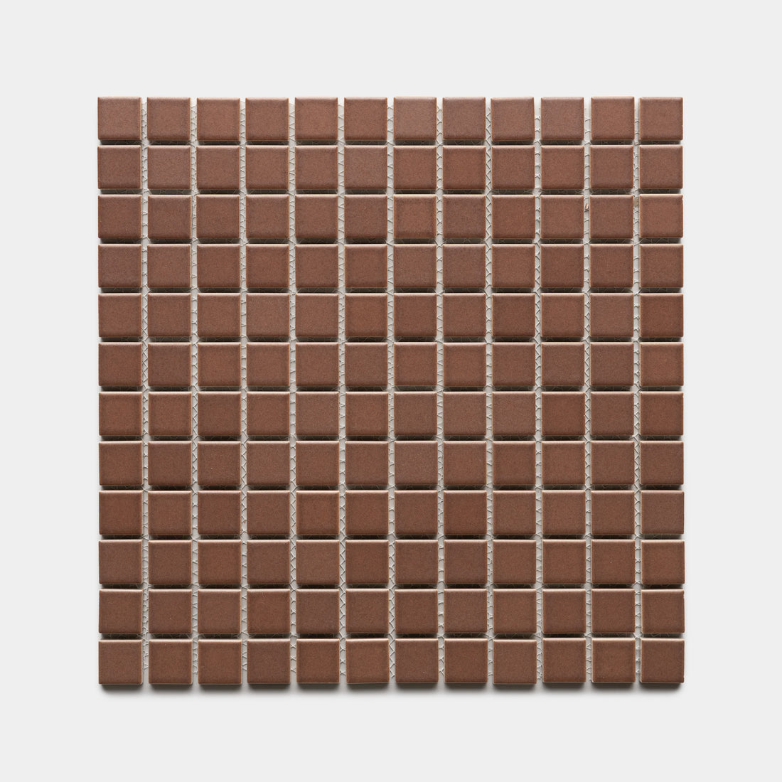 A square sheet of Zia Tile's Clove 1x1 tiles features small, evenly spaced brown ceramic squares arranged in a grid pattern on a white background.