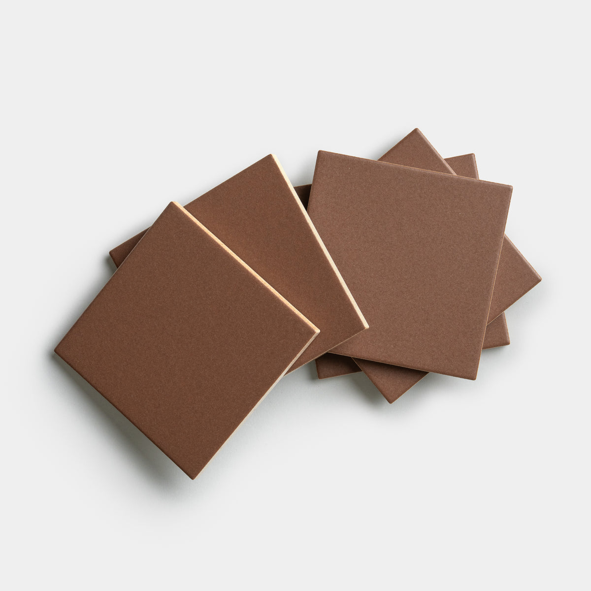 Five Clove 4x4 tiles by Zia Tile are stacked and slightly fanned out on a white background, with two tiles in the foreground overlapping three in the back.