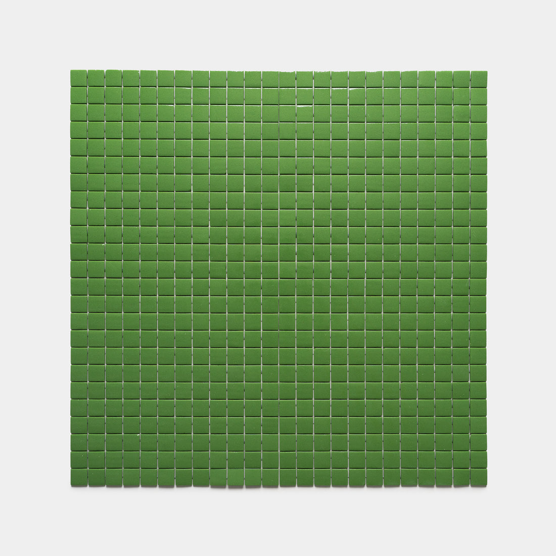 A rectangular grid of small, evenly spaced green squares from the Clover 1x1 collection by Zia Tile is arranged on a plain, light gray background.