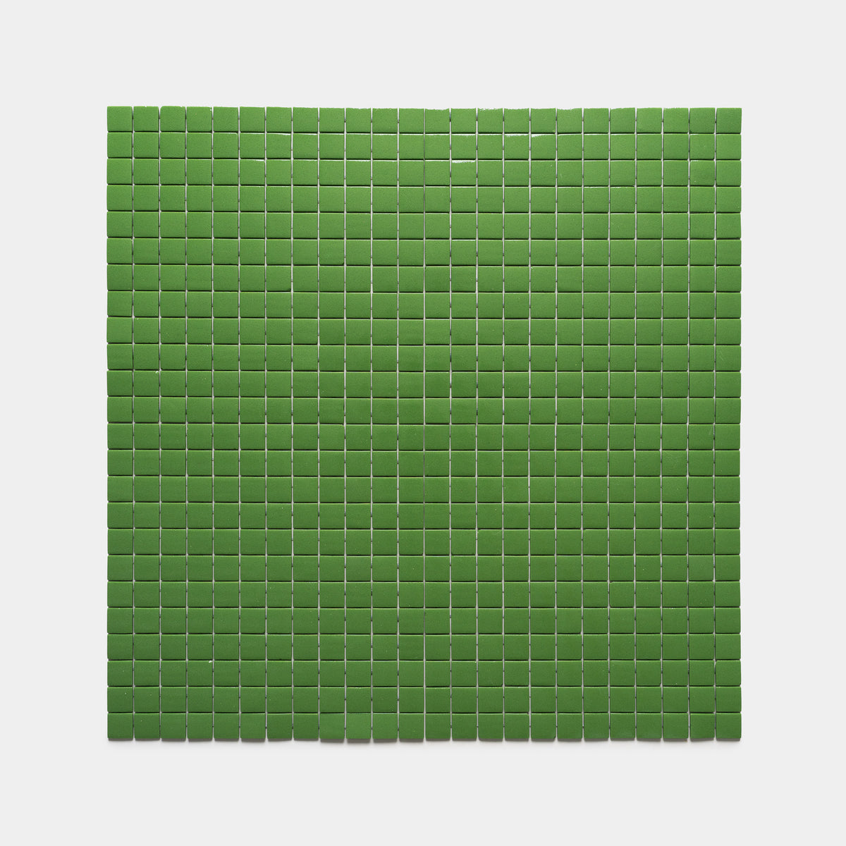 A rectangular grid of small, evenly spaced green squares from the Clover 1x1 collection by Zia Tile is arranged on a plain, light gray background.