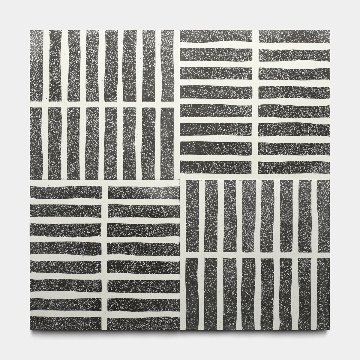 The Collins Ash 12x12 sample by Zia Tile features a square, handmade tile with four quadrants of black and white wavy grid patterns on a speckled background, creating a textured, geometric look.
