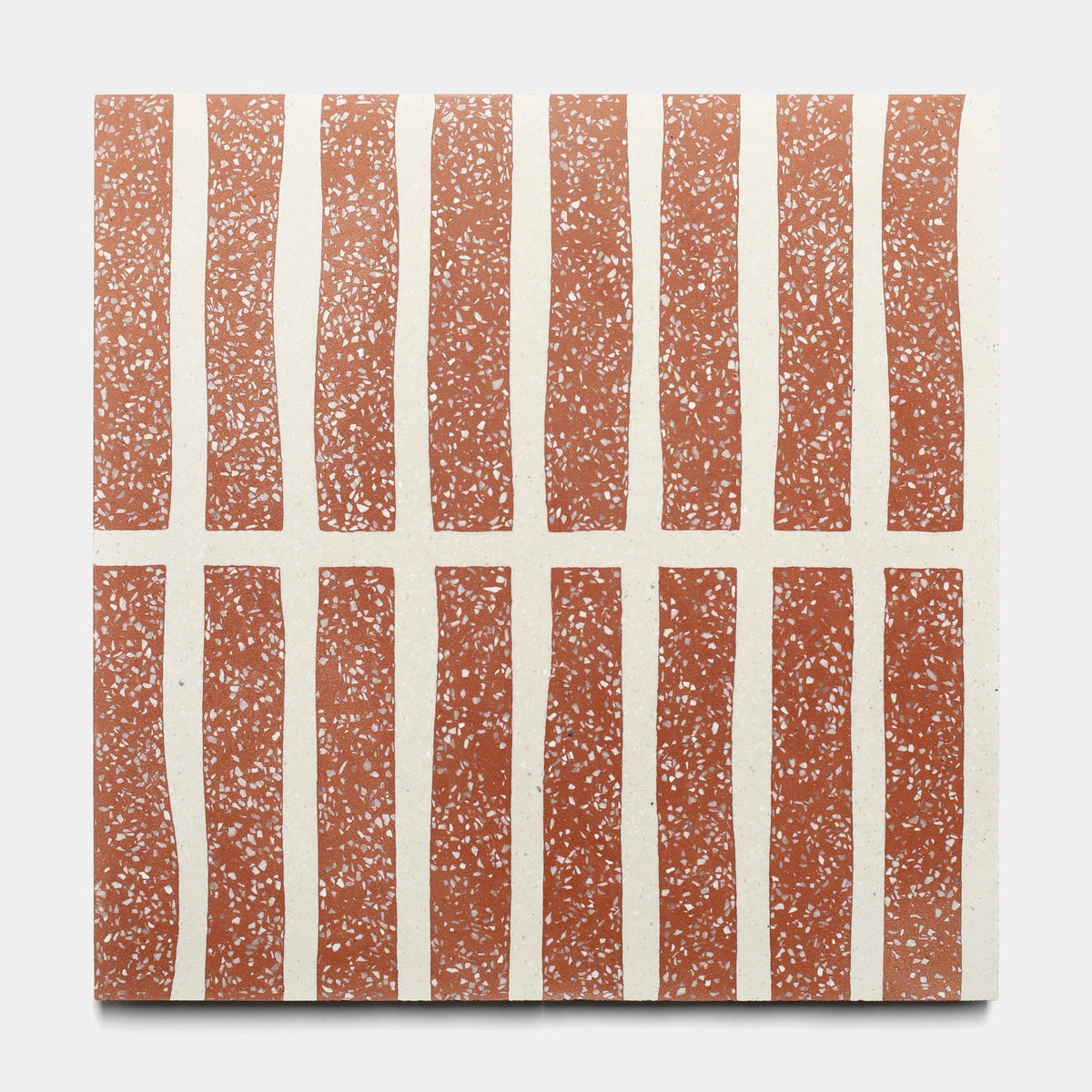 The Collins Rust 12x12 sample by Zia Tile features a square design with terracotta stripes and white speckles on a cream background, capturing the artisanal charm of handmade and classic Moroccan tiles.