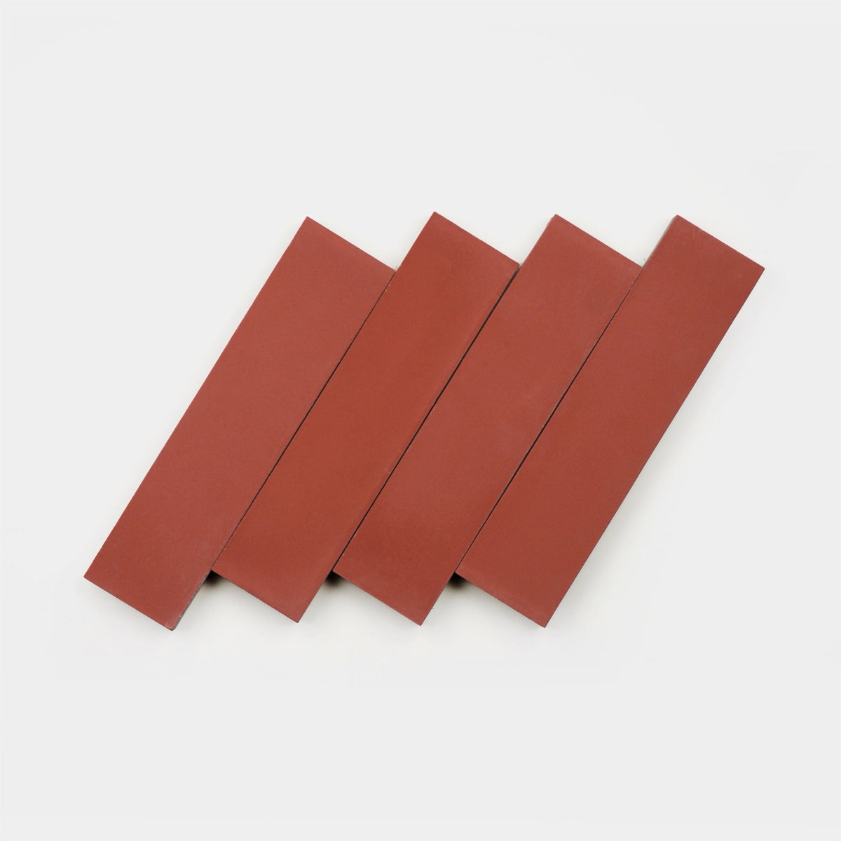 Four Coral 2x8 bricks by vendor-unknown, with a handmade look, are arranged diagonally and overlapping in a staggered pattern on a white background.