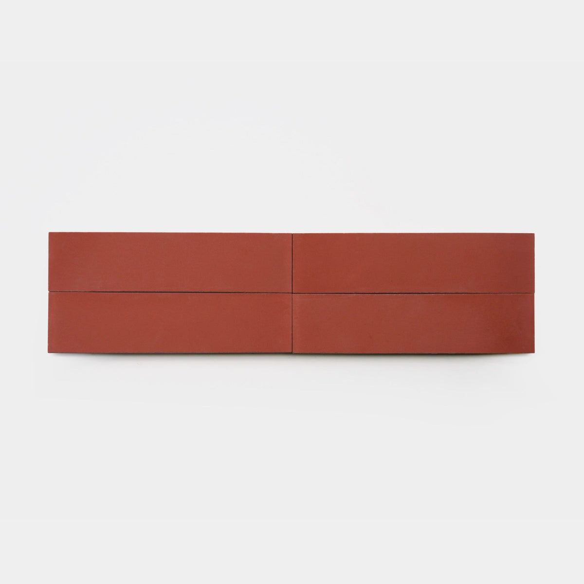 A minimalistic, rectangular sculpture of four reddish-brown blocks, reminiscent of handmade tile art by Zia Tile, features the Coral 2x8 sample from vendor-unknown arranged in two rows and two columns against a white background.