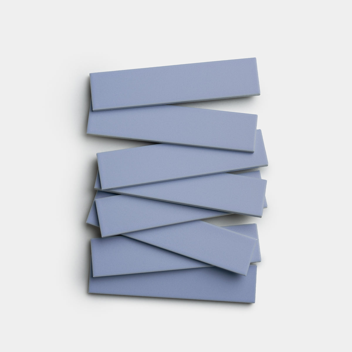 Eight rectangular Cornflower 2x8 tiles by Zia Tile are stacked unevenly in a zigzag pattern against a white background.