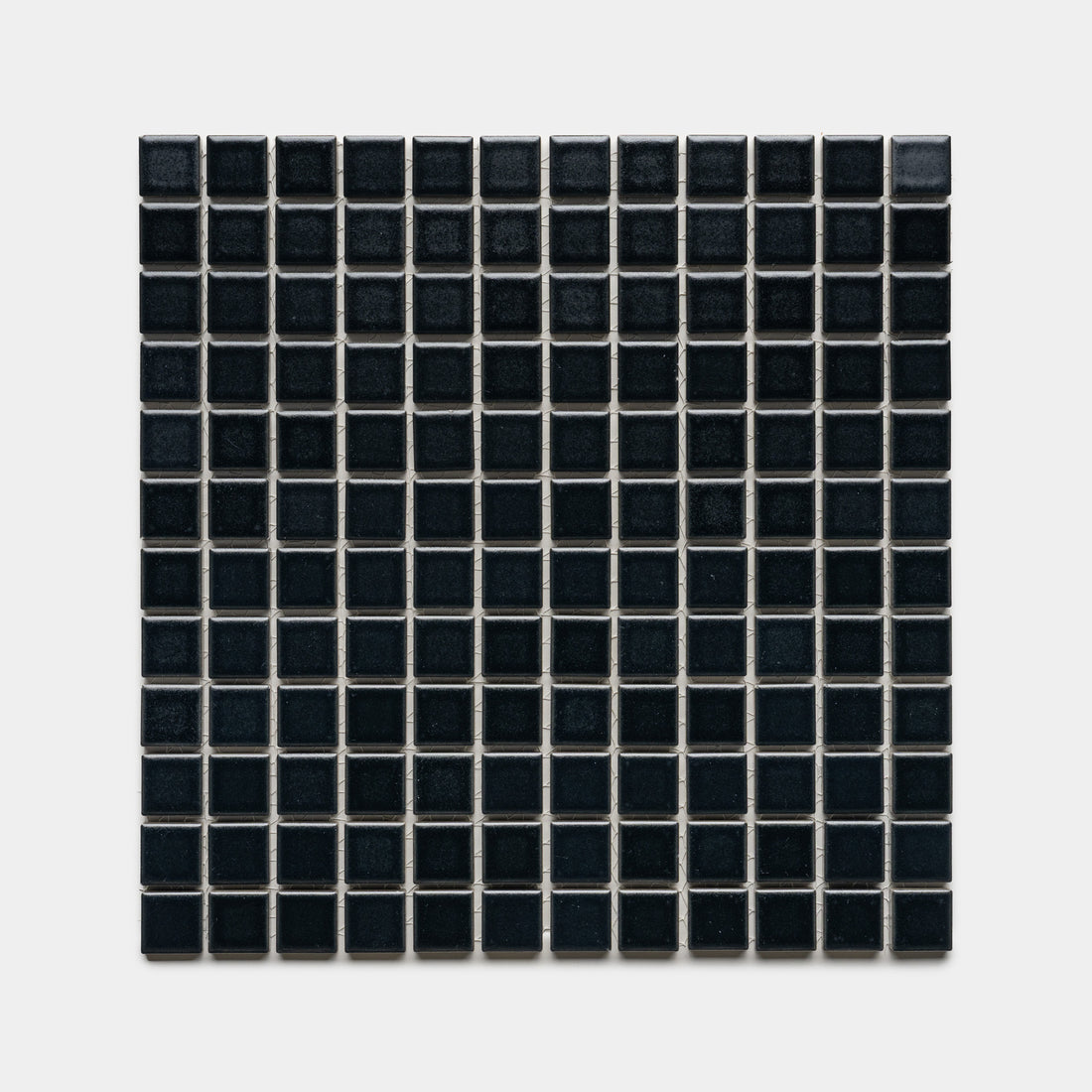 Cosmic Black 1x1 by Zia Tile features a square grid of small, glossy black tiles with thin white grout lines, arranged evenly against a plain light gray background.