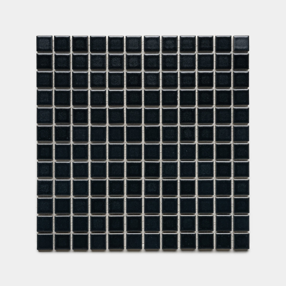 Cosmic Black 1x1 by Zia Tile features a square grid of small, glossy black tiles with thin white grout lines, arranged evenly against a plain light gray background.