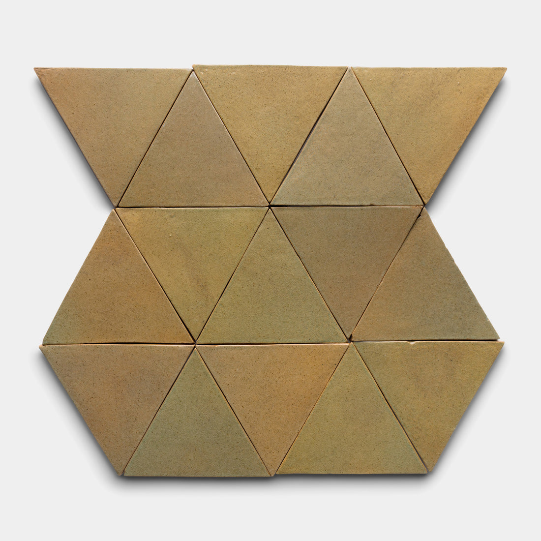Twelve Creosote Triangle tiles by Zia Tile, in brown, are arranged in a geometric pattern of alternating rows of two and three tiles on a plain white background.
