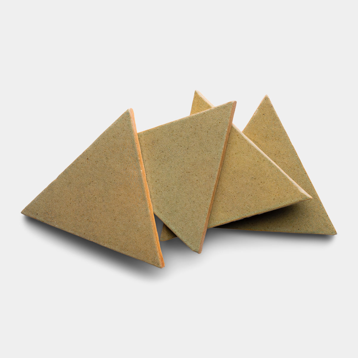 Four Creosote Triangle crackers by Zia Tile are stacked in a scattered arrangement on a plain white background.