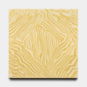 The Currents Mustard + Solar 8x8 tile from Zia Tile features a square shape with a wavy, abstract yellow and white pattern reminiscent of zebra stripes on a plain white background.