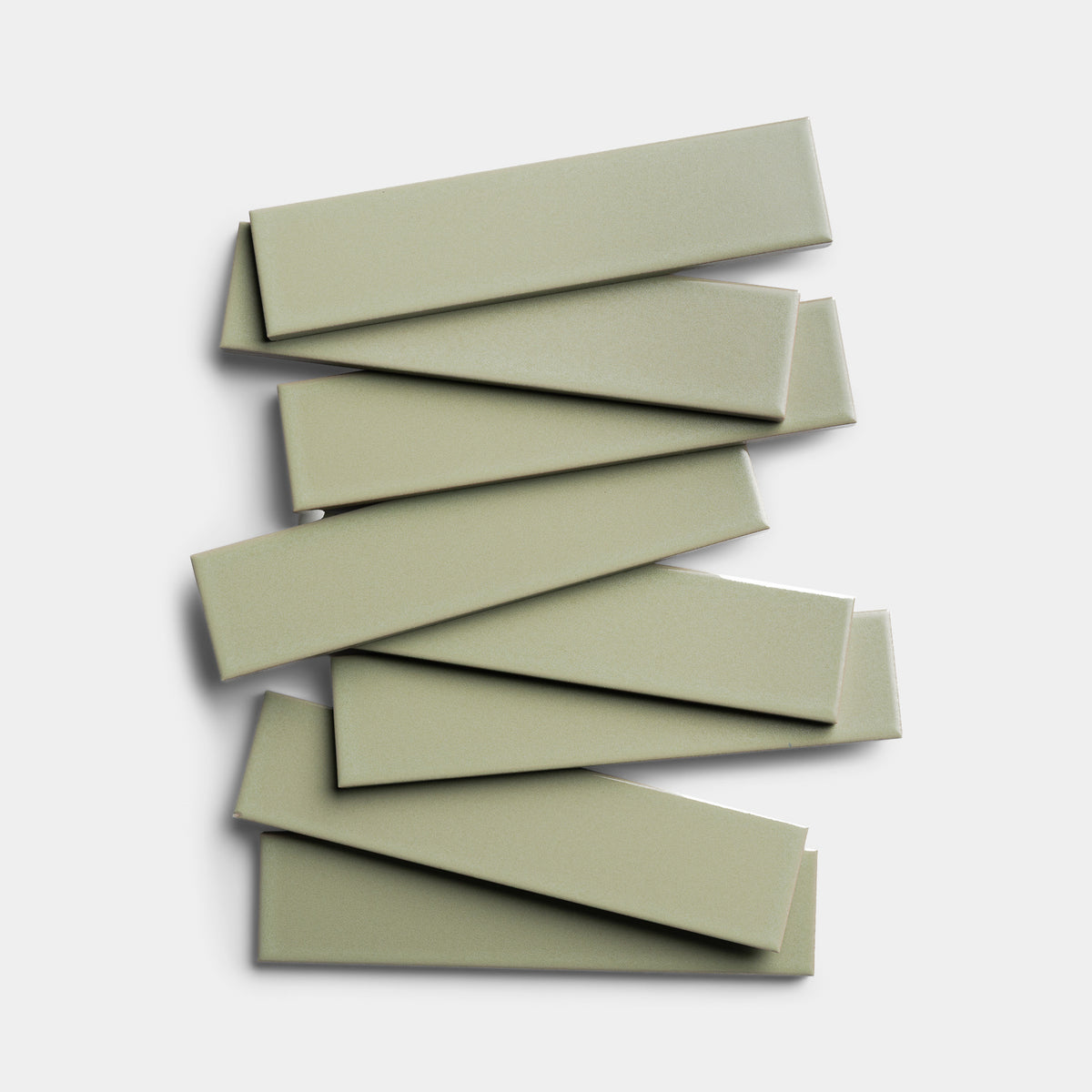Eight rectangular Cypress 2x8 ceramic tiles by Zia Tile, in light green, are stacked in a slightly offset, overlapping pattern on a plain white background.