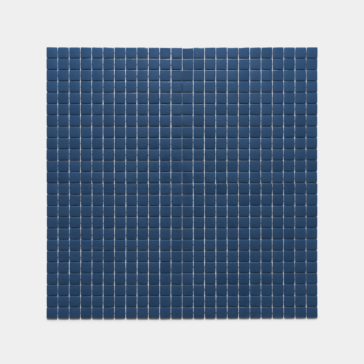 The Zia Tile Damascus 1x1 features evenly spaced, dark blue square tiles set on a light gray background, creating a neat rectangular grid pattern.