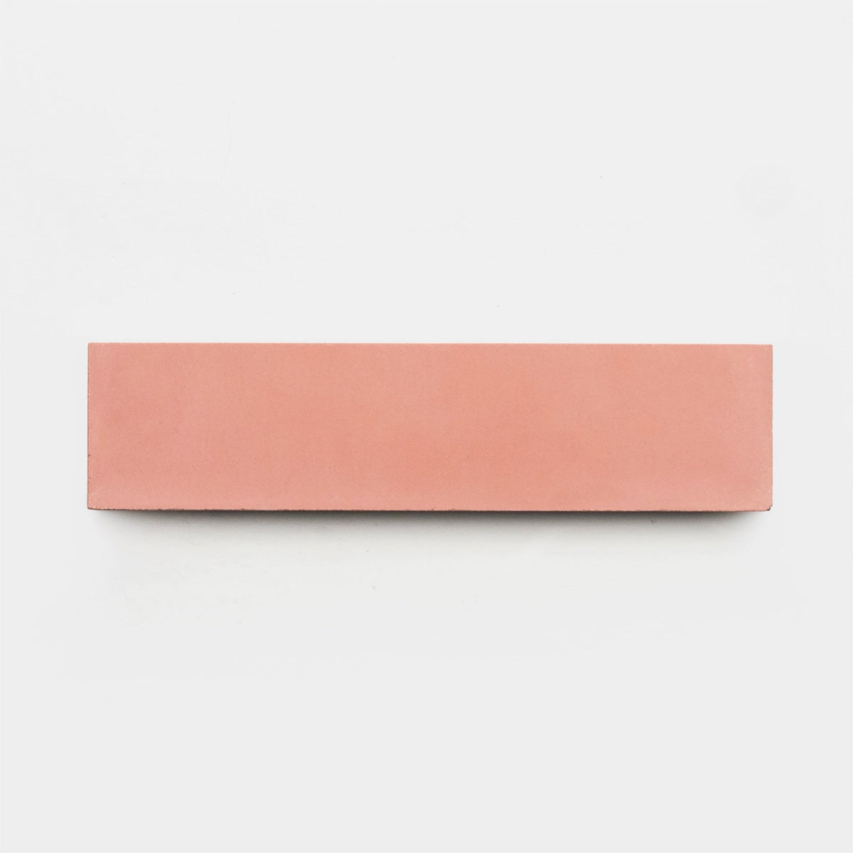 The Delta Moon 2x8 tile sample by vendor-unknown, rectangular and pink like a handmade tile, is set horizontally on a plain white background.