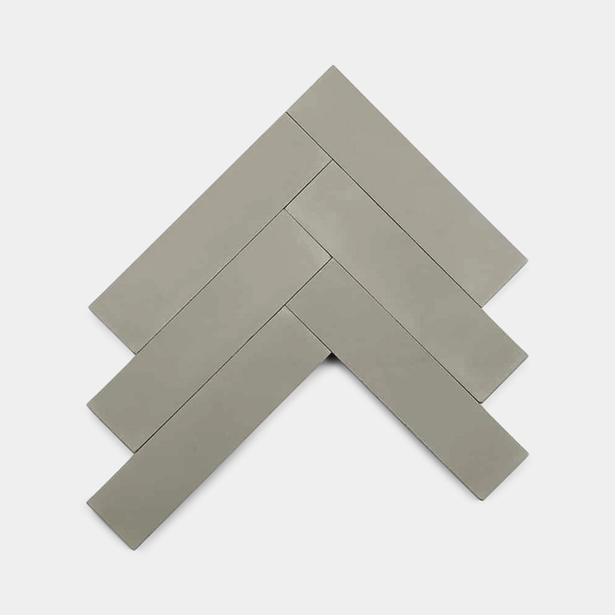 Five rectangular Desert Grey 2x8 ceramic tile samples from vendor-unknown arranged in a herringbone pattern on a plain white background.