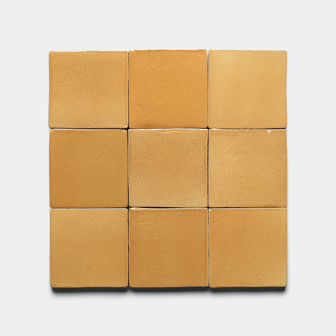 Nine Dorado 4x4 Square ceramic tiles by Zia Tile are arranged in a 3x3 grid on a white background. Each handmade tile features unique shades and textures, creating subtle variations for an artisanal look.