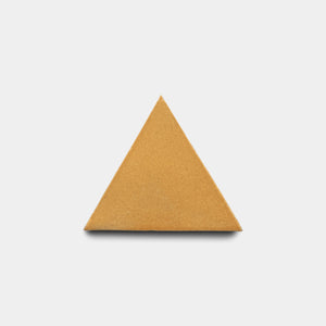 A single Dorado Triangle tile by Zia Tile, in a plain light brown color and triangular shape, is centered on a plain white background.