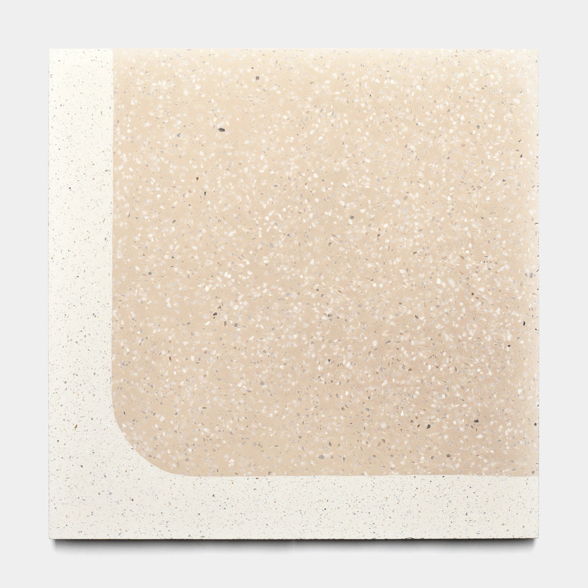 The Zia Tile Draper Dune 12x12 sample features a smooth, minimalist speckled beige surface with an off-white border on the left and bottom and a rounded lower left corner.