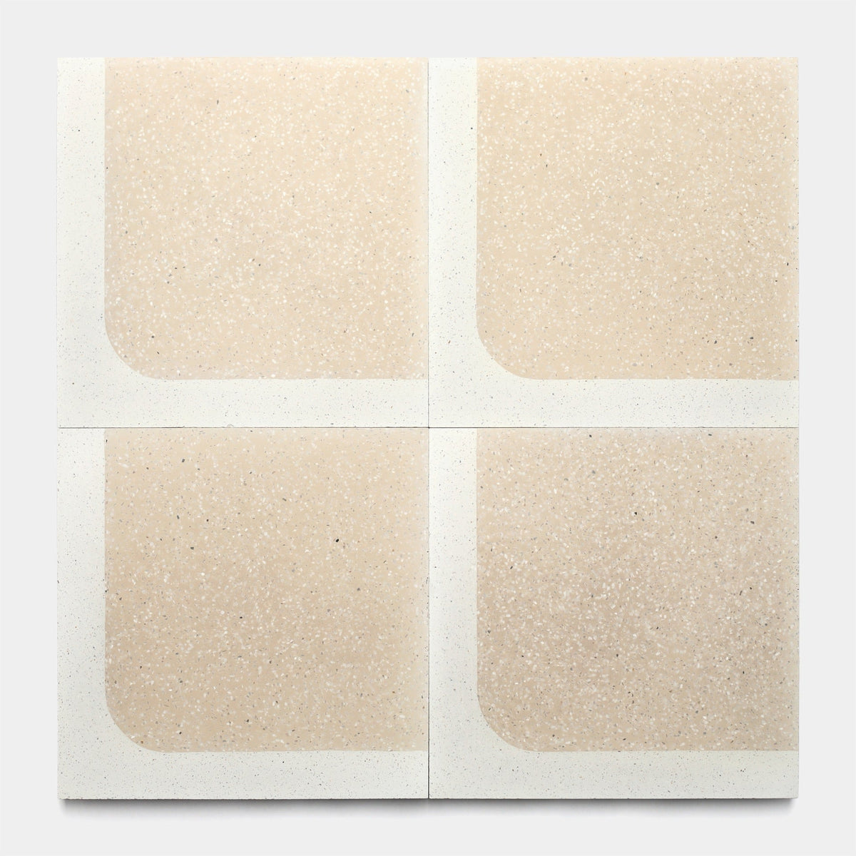 Four Zia Tile Draper Dune 12x12 samples, each with a speckled beige center and white border, are arranged 2x2. Every tile has one rounded inner corner for a symmetrical, abstract effect.