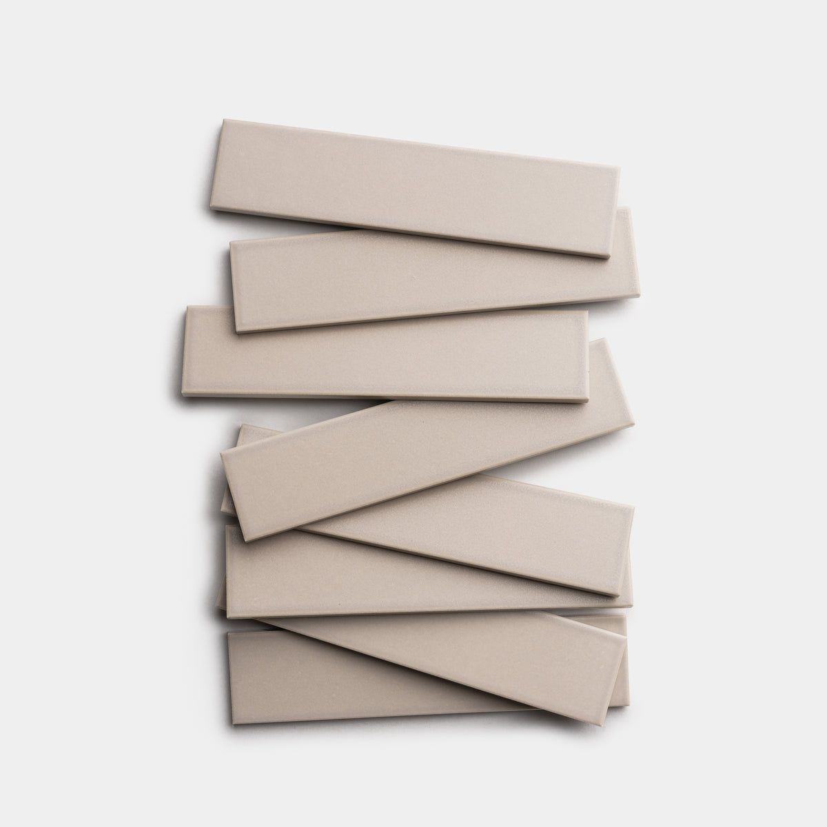 Eight Earl Grey 2x8 tiles by Zia Tile are stacked in a staggered pattern against a white background.