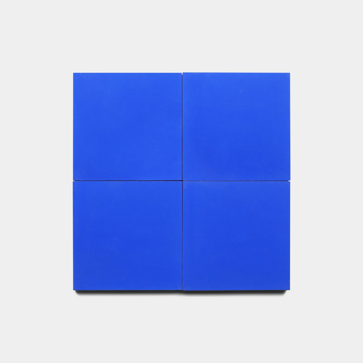 Four Elemental Blue 4x4 Sample panels by Zia Tile are arranged in a 2x2 grid on a white background, showcasing a vibrant, modern tile layout.