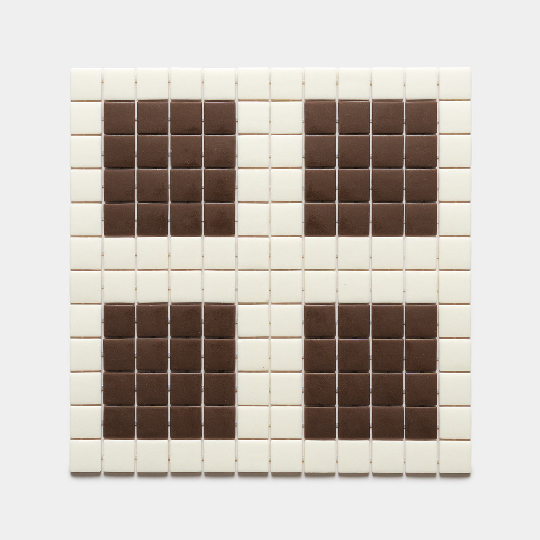 Ells Milk + Marmot by Zia Tile features a square grid of mostly white tiles with four symmetrical clusters of brown tiles in each corner, creating a distinctive pattern against a plain background.
