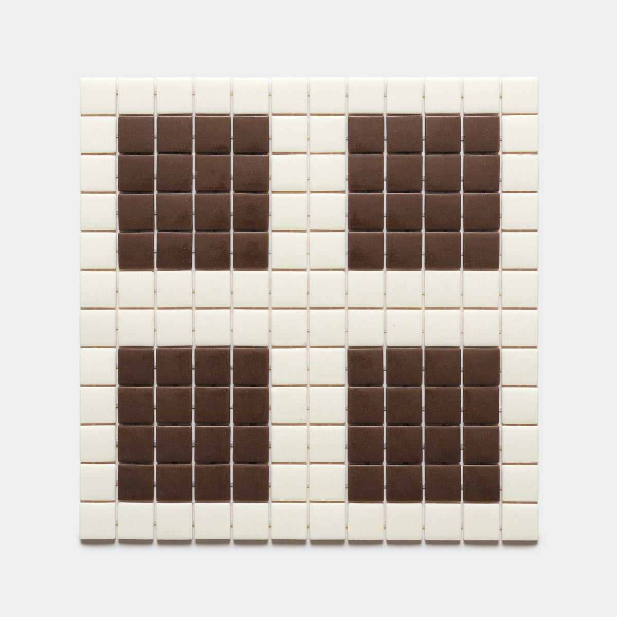 Ells Milk + Marmot by Zia Tile features a square grid of mostly white tiles with four symmetrical clusters of brown tiles in each corner, creating a distinctive pattern against a plain background.