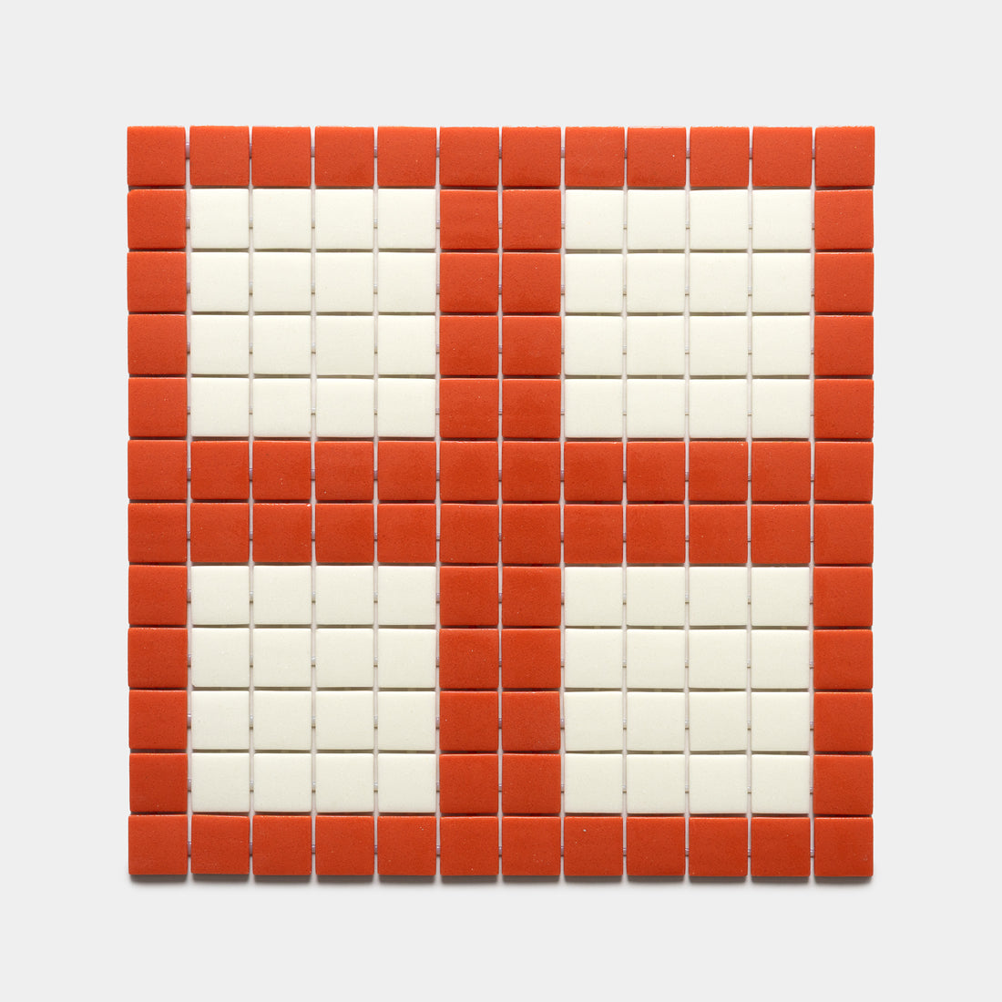 The Ells Roma + Milk tile sample by Zia Tile features a square grid pattern with red tiles outlining four white rectangles, creating a cross or windowpane effect on a white background.